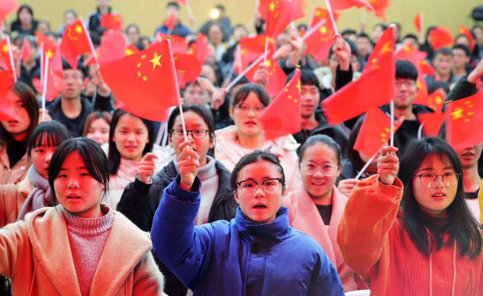 Varios estudiantes de una universidad de la provincia de Anhui ondean banderas de China, en 2018.
