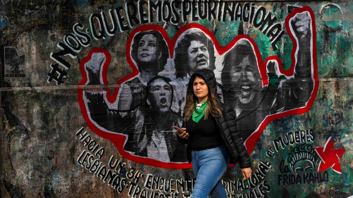 Una joven frente a una pintada en Argentina.