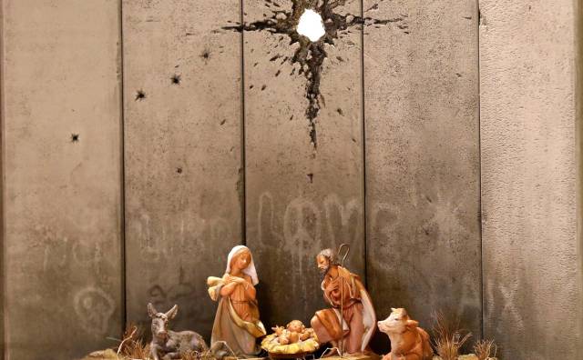 Detalle de una obra del artista británico Banksy en la fachada de 'El hotel enclaustrado' en la ciudad cisjordana de Belén (Palestina).