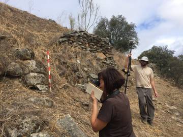 Two archaeologists, in front of the remains of the wall of Tamusia, in Botija (Cáceres).