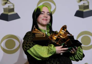 Singer Billie Eilish, who will perform at the Oscars, poses with her Grammy Awards at the last edition of the event.