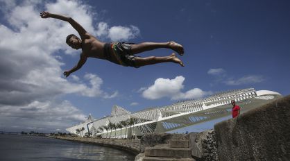 A young man dives into the water in Plaza Mauá
