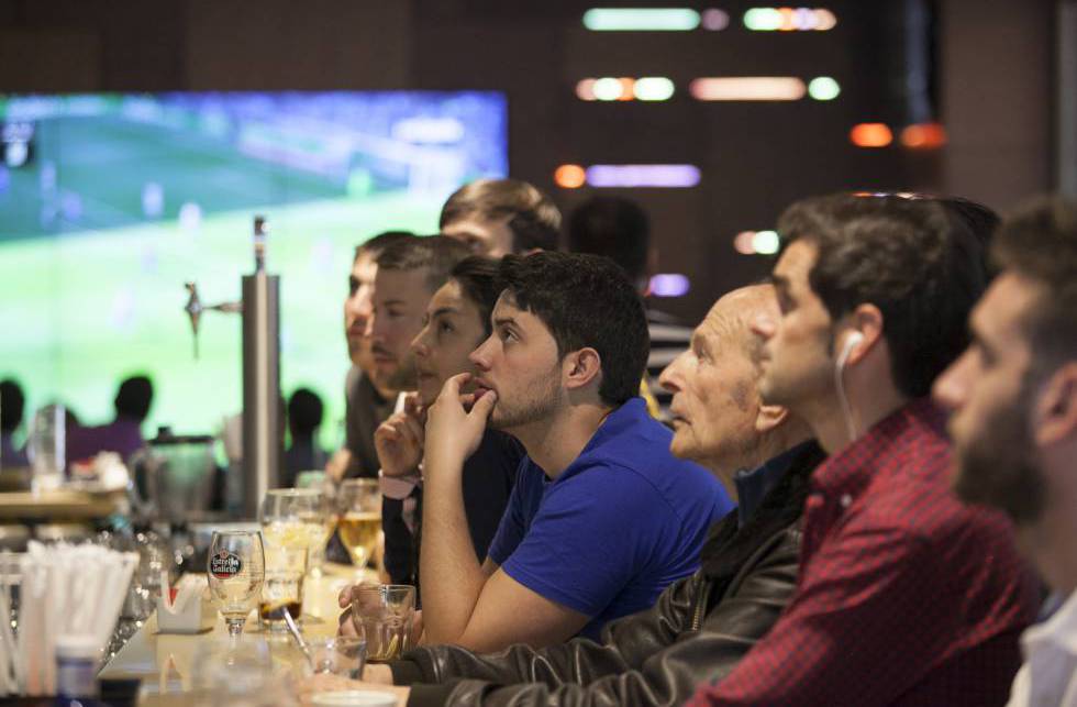 Aficionados viendo fútbol en una casa de apuestas.