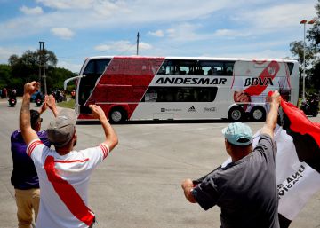 Hinchas de River saludan al autobús que lleva al equipo al aeropuerto.