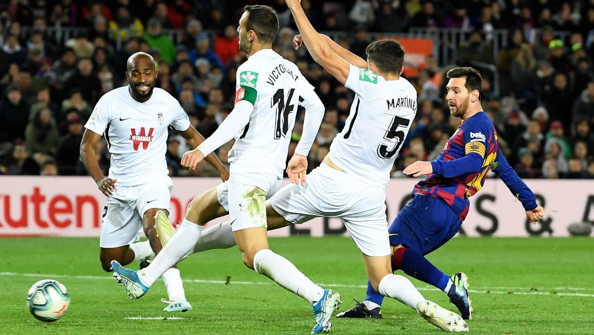 Messi supera a los defensas del Granada.