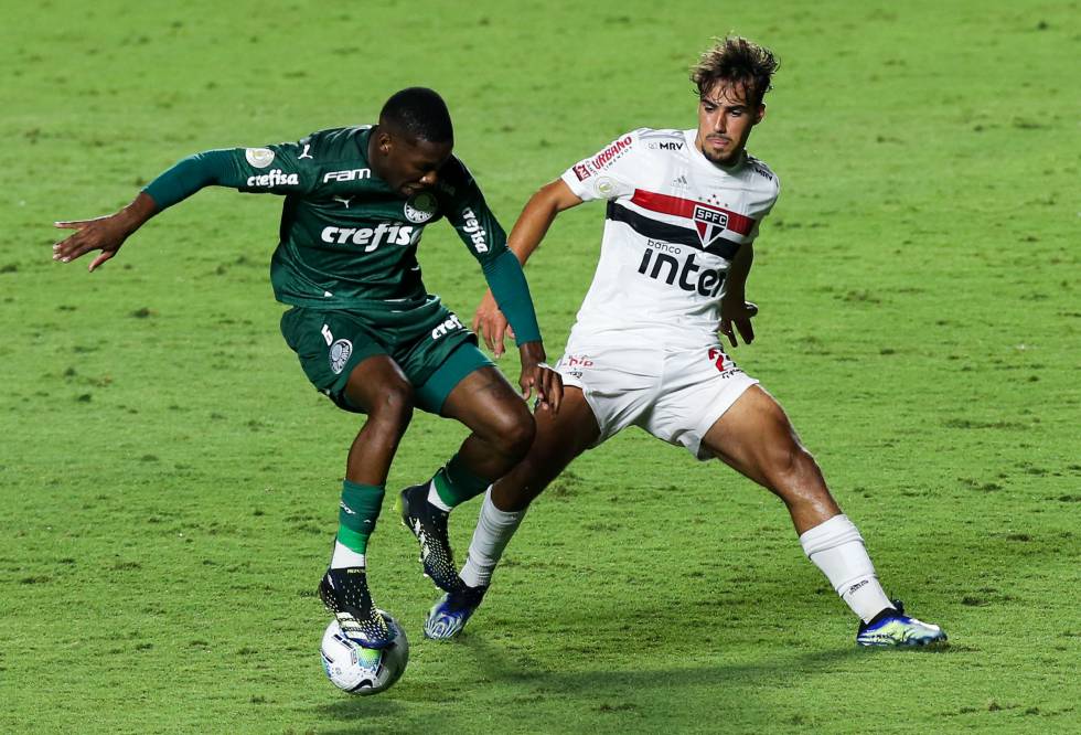 Patrick de Paula, de verde, con la camiseta del Palmeiras, pisa el balón ante la marca de un jugador del São Paulo.