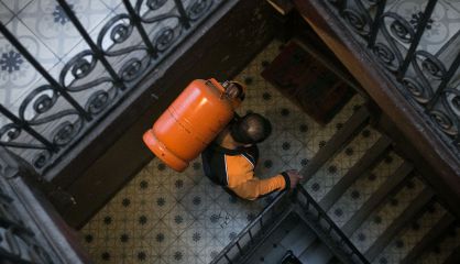 Un butanero sube una bombona a un piso de Barcelona.