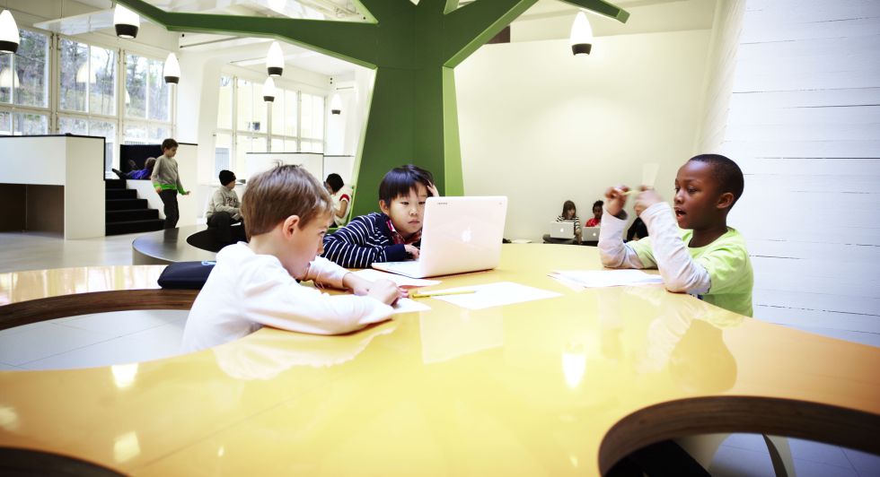 Un grupo de niños en una de las mesas orgánicas diseñadas por Rosan Bosch Studio, en la que los alumnos deciden a qué distancia quieren trabajar.