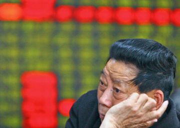 Un inversor frente a los paneles de la Bolsa en Shangh&aacute;i (China)