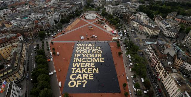 Cartel extendido en la plaza Plainpalais de Ginebra en la campa&ntilde;a por el s&iacute; a la renta b&aacute;sica.