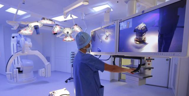 Un enfermero en un quirófano con equipos digitales.