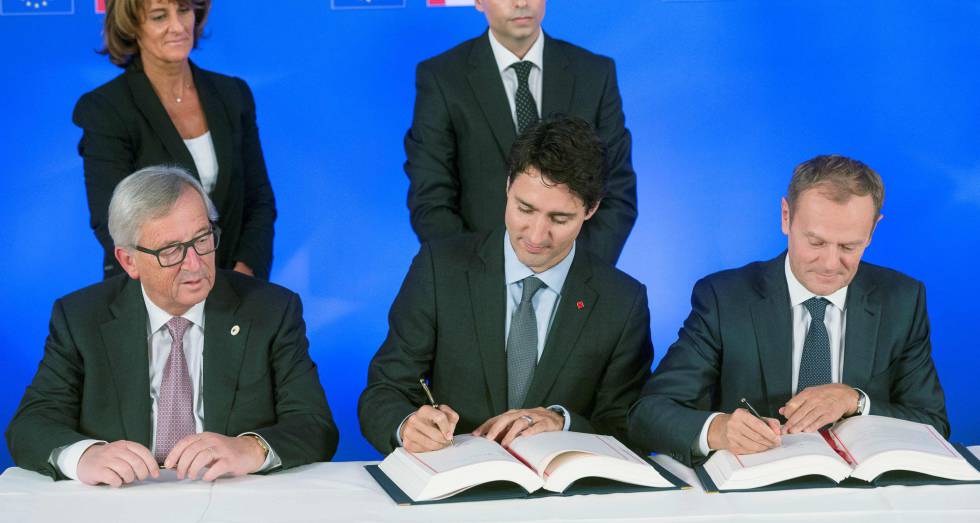 De izquierda a derecha, el presidente de la Comisión Europea, Jean-Claude Juncker, el primer ministro de Canadá, Justin Trudeau, y el presidente del Consejo Europeo, Donald Tusk, suscriben el CETA.