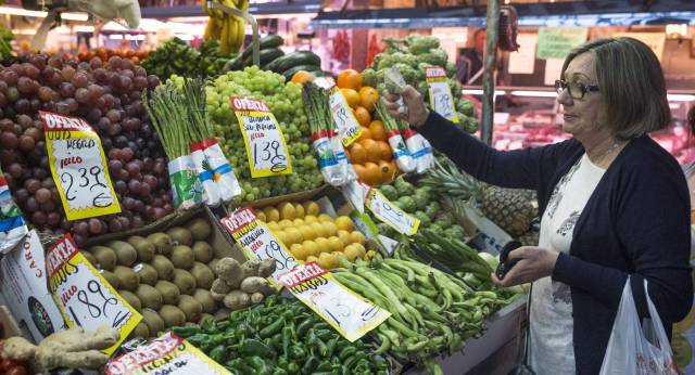 Una mujer hace su compra en una fruter&iacute;a del mercado Maravilla en Madrid