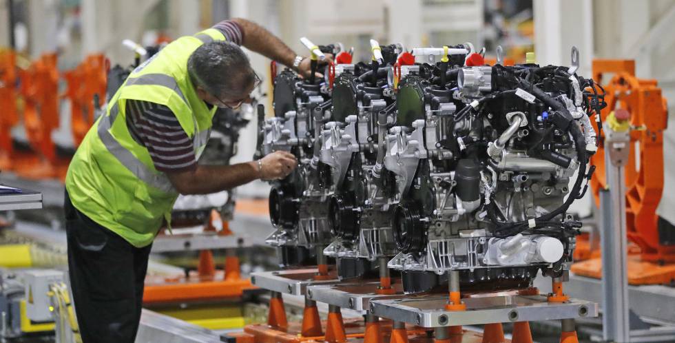 Un empleado de Ford trabaja con un motor diésel en una planta de Londres.