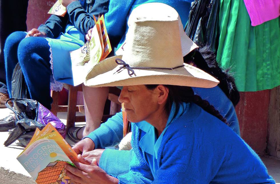 Una mujer de Cajamarca lee el folleto explicativo del proyecto Luz en Casa.