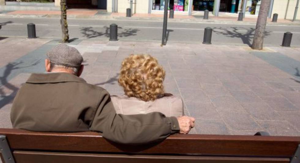 Una pareja de ancianos toma el sol en un banco