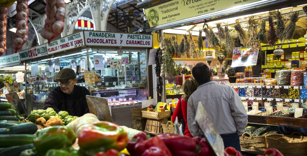 Puesto de frutas y verduras y una panaderÃ­a, en el Mercado Central de Valencia.
