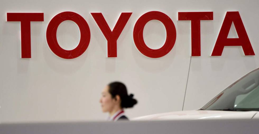 Una empleada de Toyota camina debajo del logo de la compañía en uno de los concesionarios de la compañía en Tokyo. 