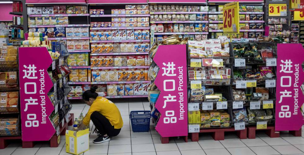 Un reponedor coloca productos importados en un supermercado de Shanghái.