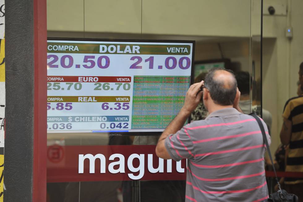 Un hombre observa una pizarra con la cotizaciÃ³n del dÃ³lar en una casa de cambio en Buenos Aires.