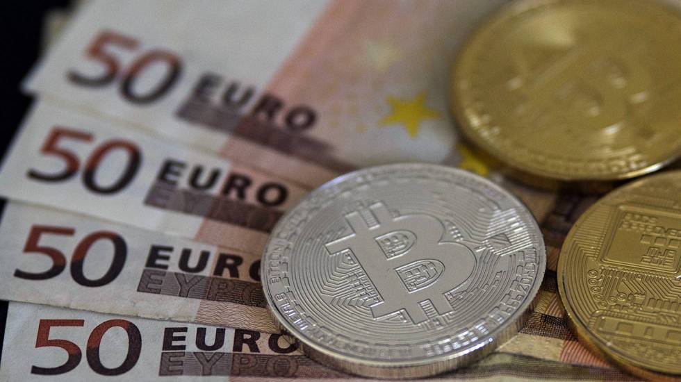  Imagen de monedas de bitcoin y billetes en euros.