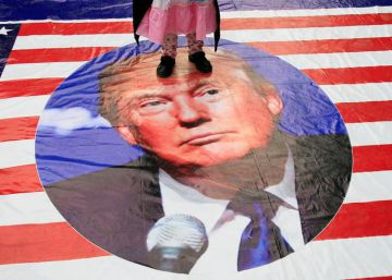 Una niña pisa un cartel con el rostro de Donald Trump. 