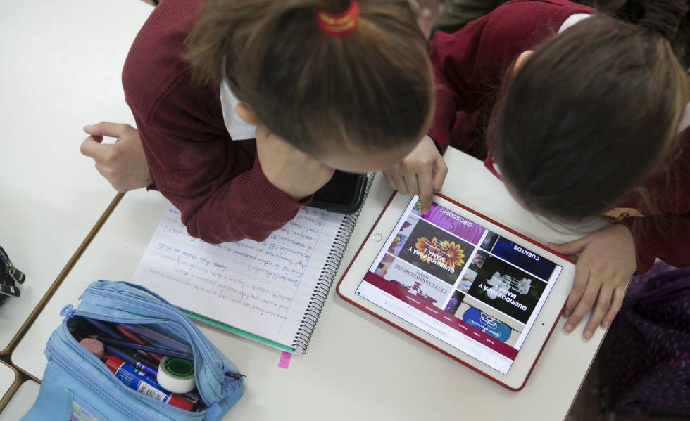 Dos niÃ±as trabajan en clase con una tableta.