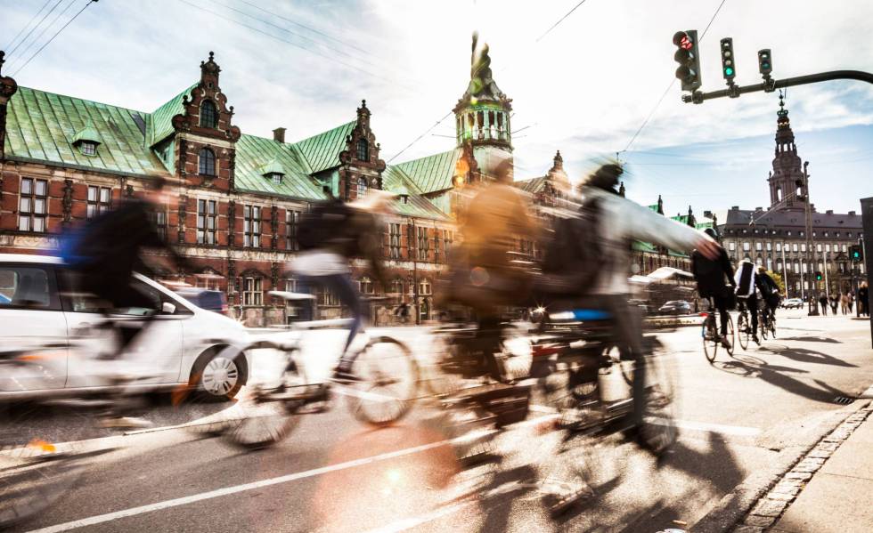 Ciclistas en Copenhague, con el edificio de la Bolsa al fondo.