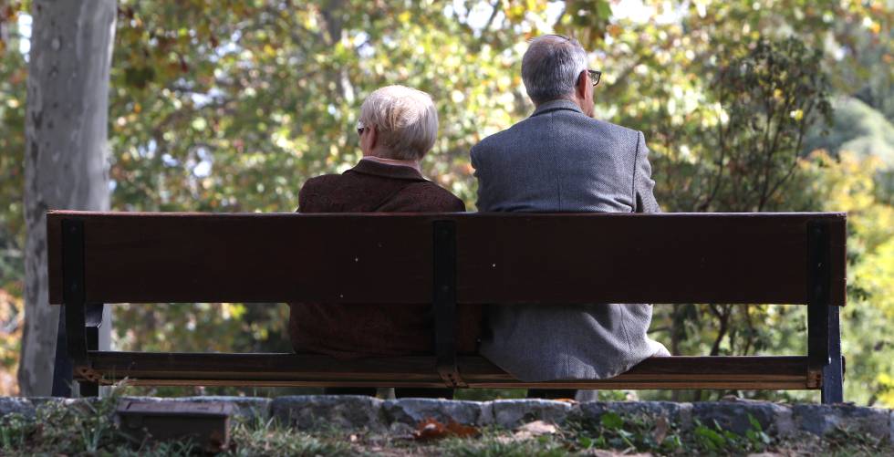 Dos ancianos sentados en un banco del Retiro, en Madrid.