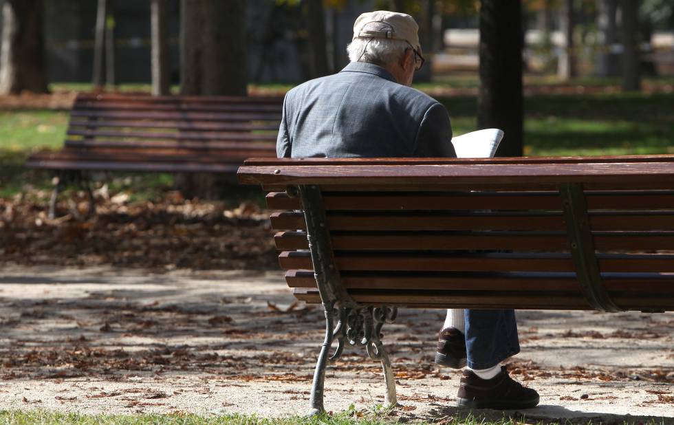 Un jubilado lee el periódico en un parque de Madrid.