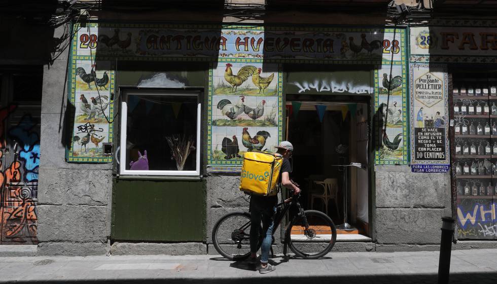 Un repartidor de comida, ante la antigua fachada de un local reconvertido en restaurante en Madrid.