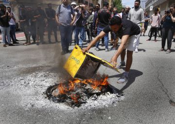 Un grupo de trabajadores queman mochilas ante la sede de Glovo  