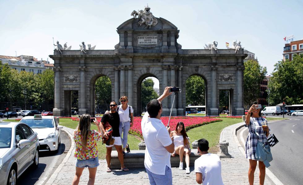 Turistas se fotografían en la madrileña Puerta de Alcalá.