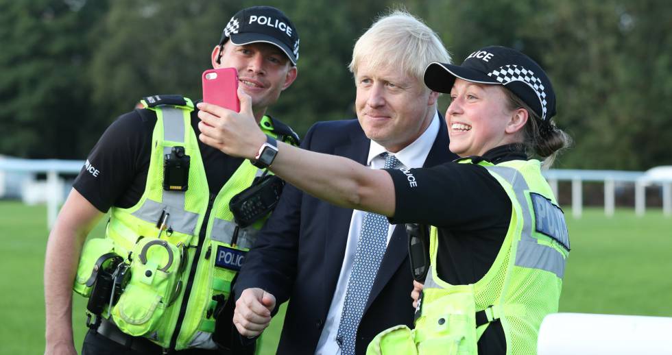 El primer ministro británico, Boris Johnson se fotografÃa con dos policÃas en un acto el pasado viernes.