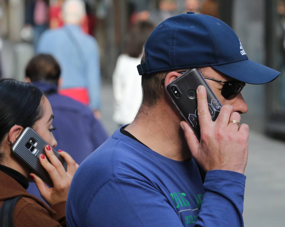 Dos personas hablan por el móvil en el centro de Madrid.