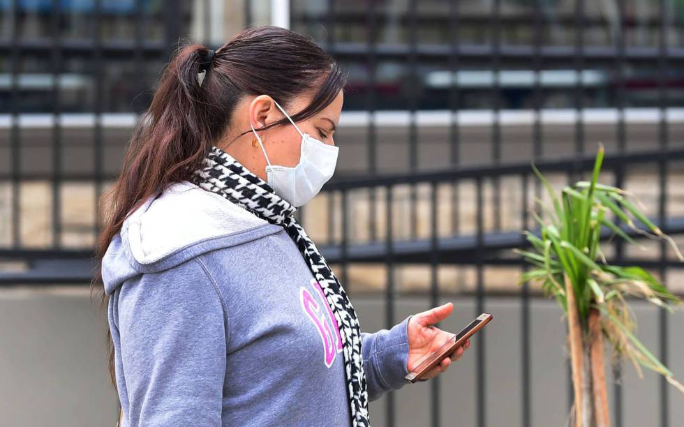 Una mujer consulta su dispositivo móvil.  (AFP)