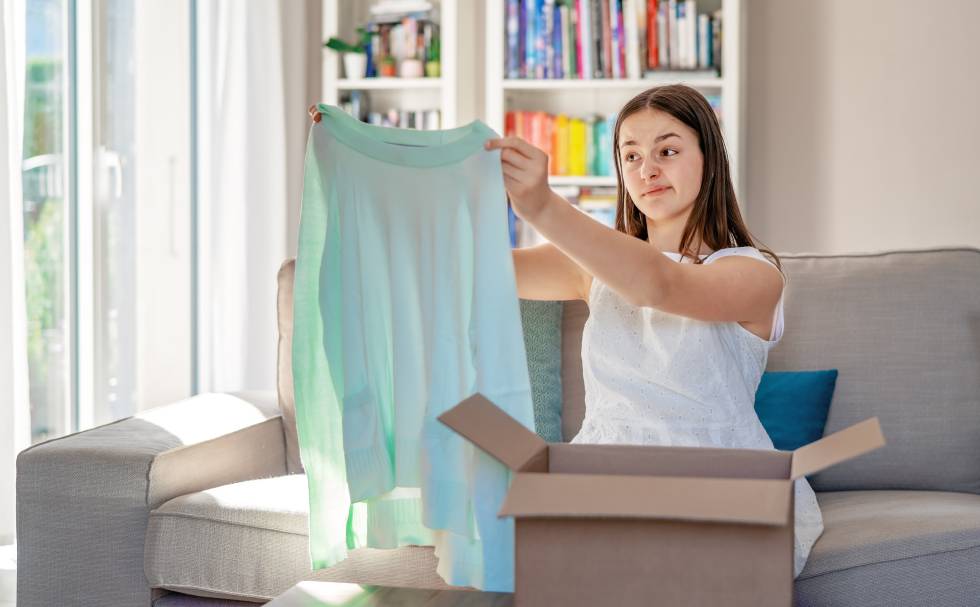 Una chica comprueba que ha comprado por Internet una blusa con una talla equivocada.