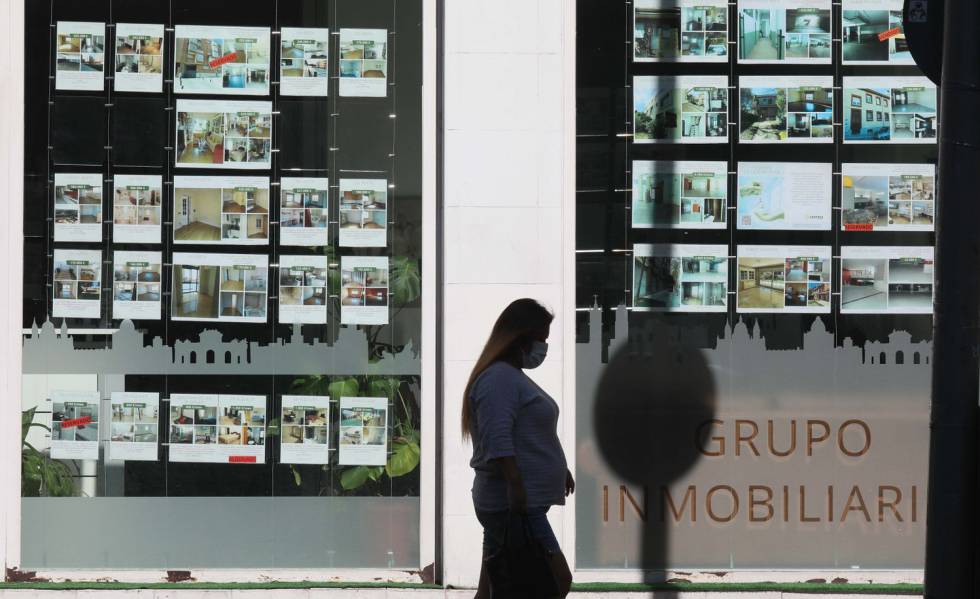 Una mujer pasa delante de una agencia inmobiliaria, en junio.