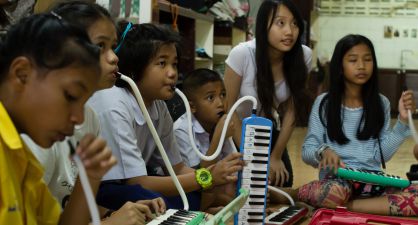 Un grupo de alumnos de Playing for Change aprende a tocar una melódica.