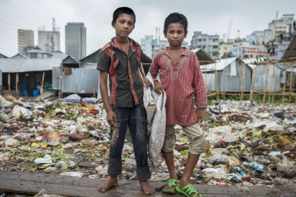 Shopon (11 años) y Akash (10 años) trabajan rebuscando en la basura del vertedero de Korail, en Dacca, capital de Bangladesh.
