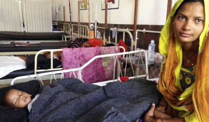 Anisha Khatoon está sentada en una cama de la MICU, la Unidad de Cuidados Intensivos para Desnutridos, donde espera que su hija Najina, de año y medio, se recupere.