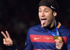 Barcelona forward Neymar holds his gold medal on the podium during the awarding ceremony after winning the Club World Cup football final against River Plate in Yokohama on December 20, 2015. AFP PHOTO  TOSHIFUMI KITAMURA