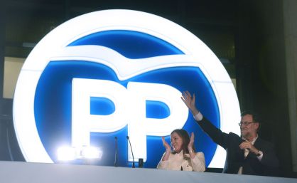 PM Mariano Rajoy waves next to his wife Elvira Fernandez at PP HQ.