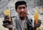 Un minero ense&ntilde;a los pedazos de azufre que venden a los turistas en el volc&aacute;n Kawah Ijen, en Indonesia.