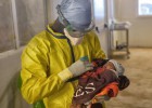 Un trabajador de MSF sostiene a una ni&ntilde;a en el centro de tratamiento de &eacute;bola de Conakry.