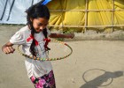 Una niña juega con un aro en el campo de desplazados de Chuchepati.