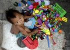 Un ni&ntilde;o sin hogar y sus juguetes recogidos por sus padres en las calles de Manila, Filipinas.