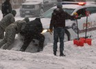 Varias personas sacan de la nieve un coche de polic&iacute;a en Washington.  