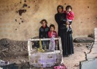 Una mujer y sus hijos están en las ruinas de su casa en la ciudad kurda de Silopi, Turquía.rn 
