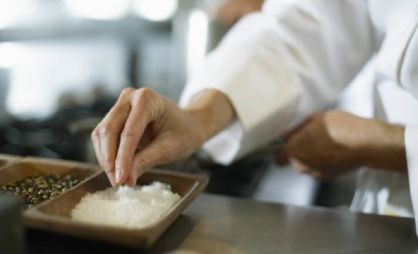 Una persona coge sal en un restaurante.